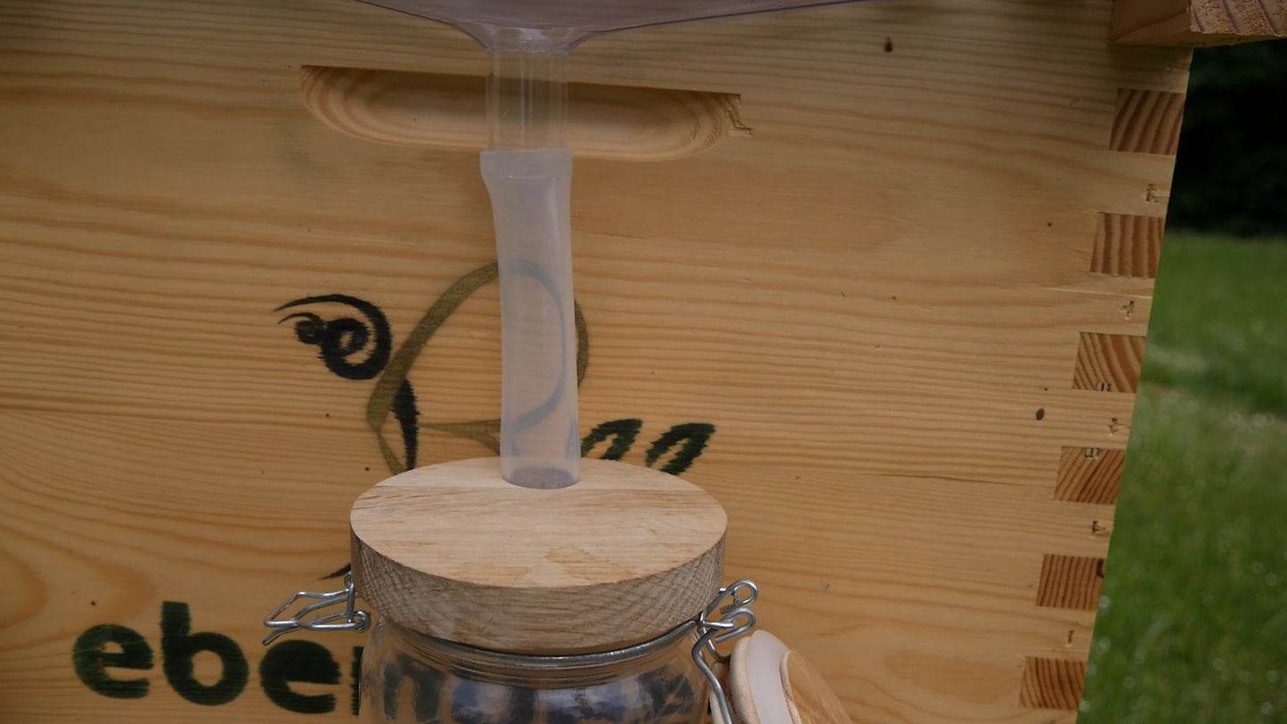 Wooden lid for the honey pot with a silicone tube.